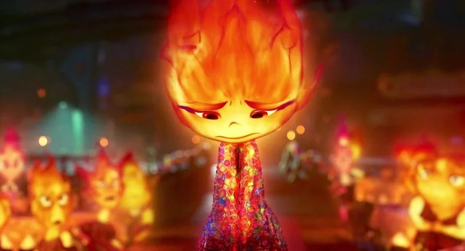 Elemental (2023) movie still: closeup — A crowded public space with soft-focus background characters lit by warm fire-like light. A singular flame…
