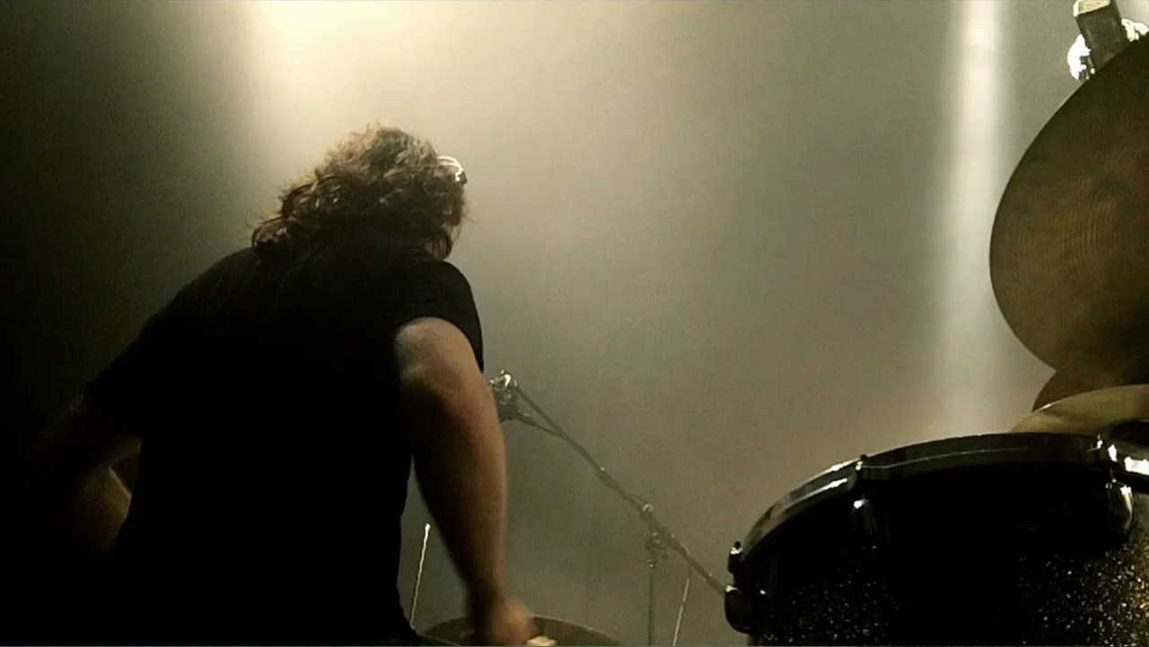 Soaring Highs and Brutal Lows: The Voices of Women in Metal (2015) movie still: medium — A dark concert stage filled with light haze and a single…