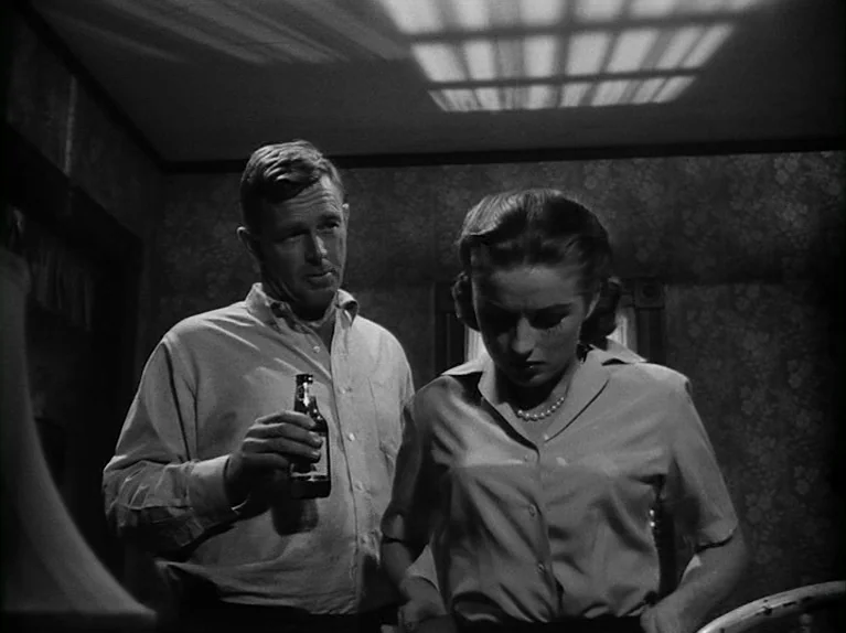 The Killing (1956) movie still: medium — A dimly lit room features patterned wallpaper and a ceiling with window-pane shadows. A man holding a…