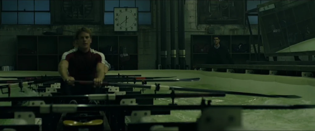 The Social Network movie still: medium — An indoor training facility features a long water tank and industrial lockers.