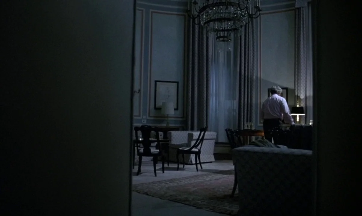 Cinema Paradiso (1988) movie still: wide — A dark, formal room features a chandelier, high curtains, and traditional upholstered furniture. An older…