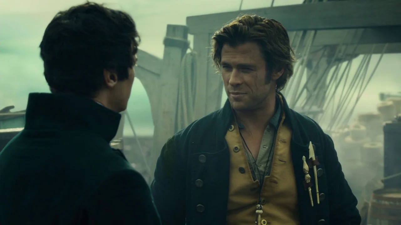 In The Heart of the Sea (2014) movie still: medium — The deck of a 19th-century whaling ship is shrouded in hazy coastal fog. Two men converse while…