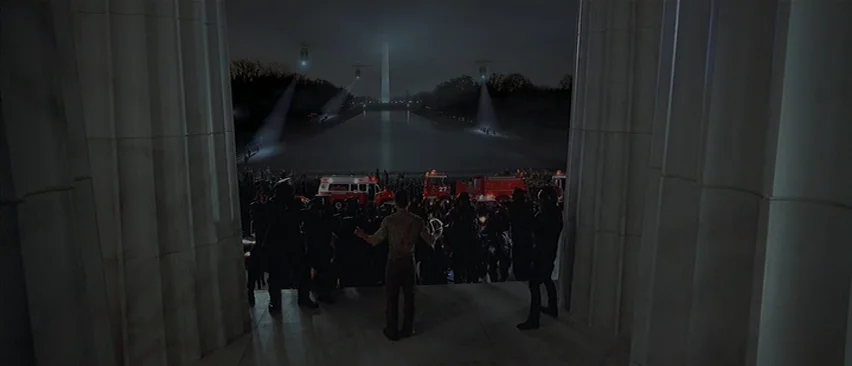Planet of the Apes (2001) movie still: wide — The steps of a stone monument look out over a dark pool at night. Helicopters hover in the distance…