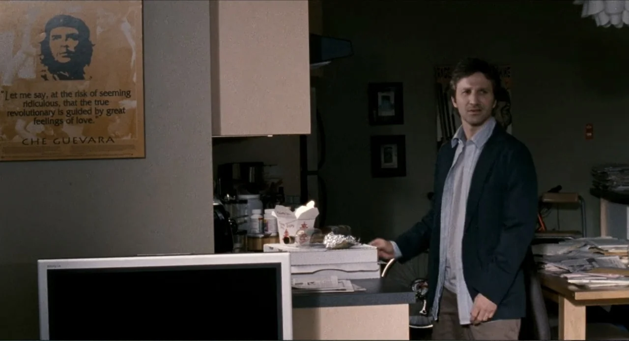 Colin Quinn: Red State, Blue State (2019) movie still: medium — A cluttered apartment kitchen features a Che Guevara poster mounted on a grey wall.…