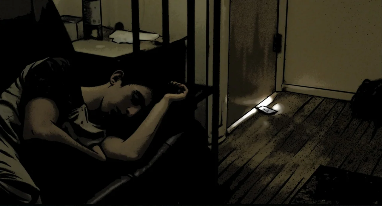 Freedom (2024) movie still: medium — A dark, spartan bedroom contains a bed frame and a wooden floor illuminated by a phone. A young man rests with…