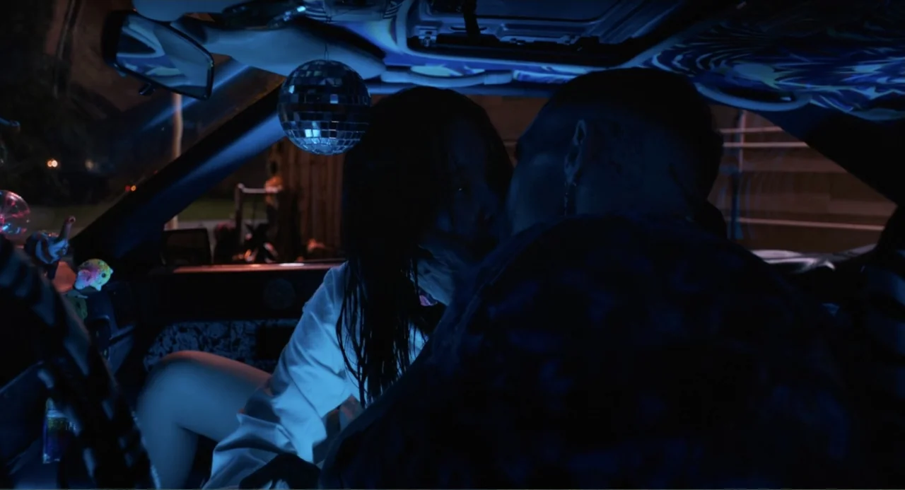 Mona Lisa and the Blood Moon (2022) movie still: medium — The interior of a vehicle features a dangling disco ball above the occupants. A young…
