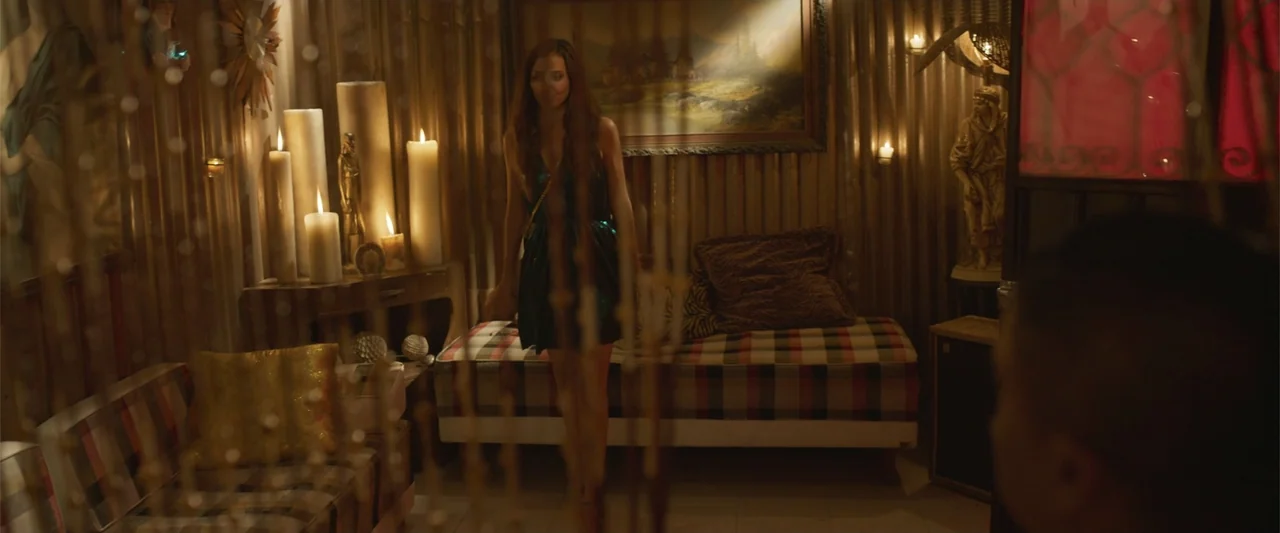 Crazy for Change (2020) movie still: fullbody — A dimly lit room filled with large pillar candles and framed landscape paintings. A young woman…