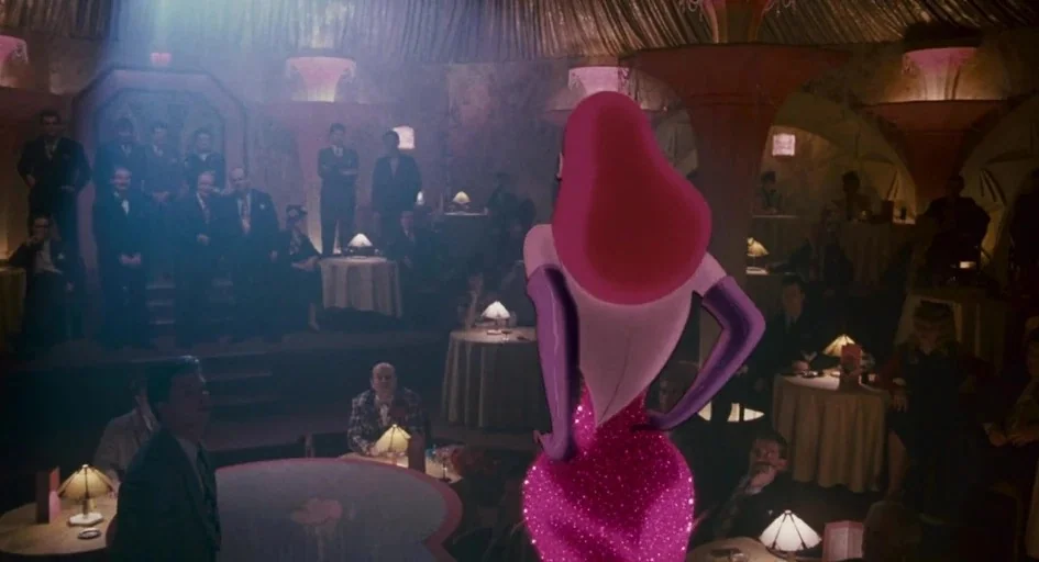 Who Framed Roger Rabbit (1988) movie still: medium — A dimly lit club filled with patrons seated at tables around a central stage. An animated woman…