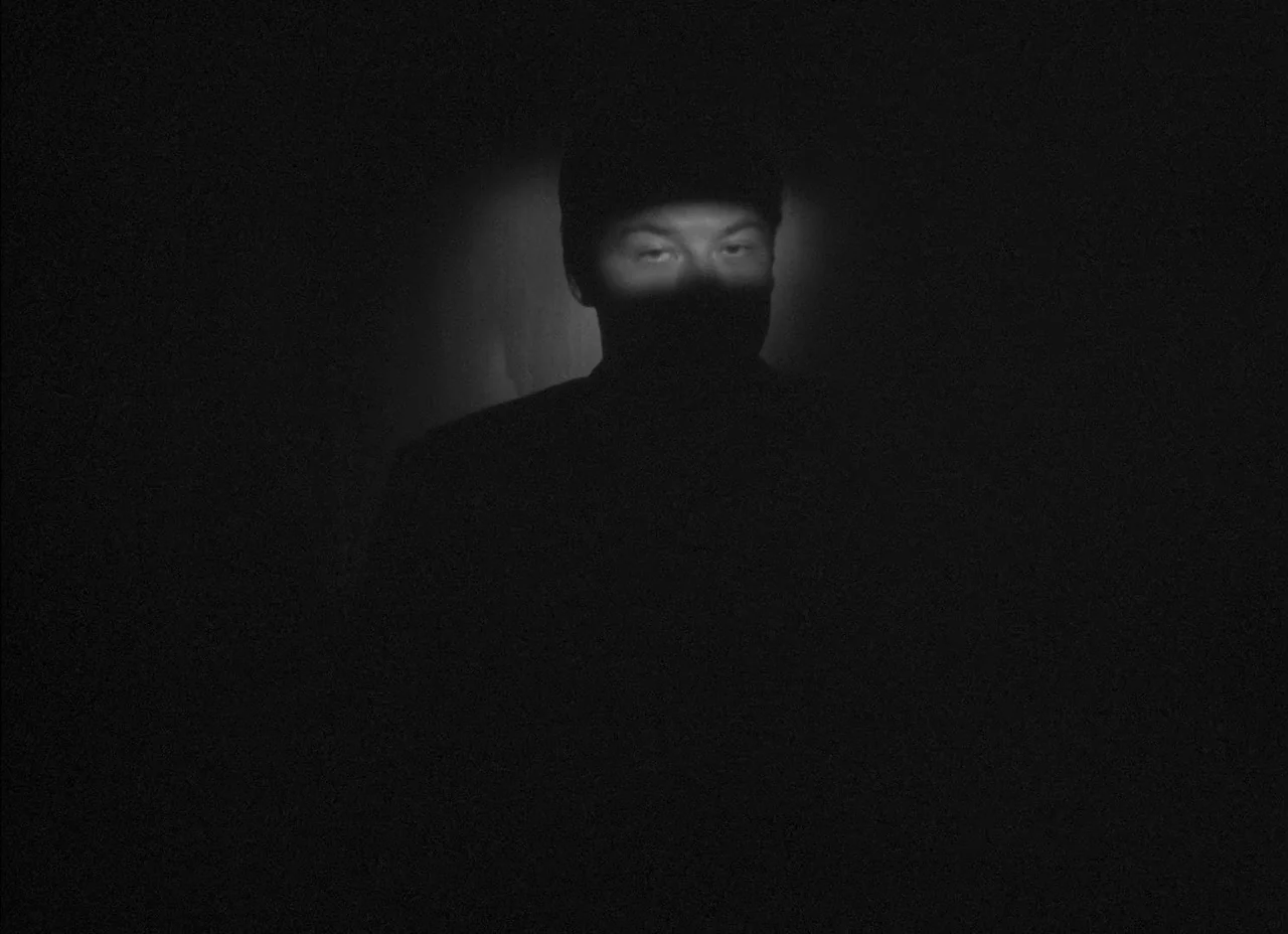 The Amazing Mr. X (1948) movie still: closeup — A pitch-black environment with only the subject's eyes and brow illuminated. The man gazes forward…