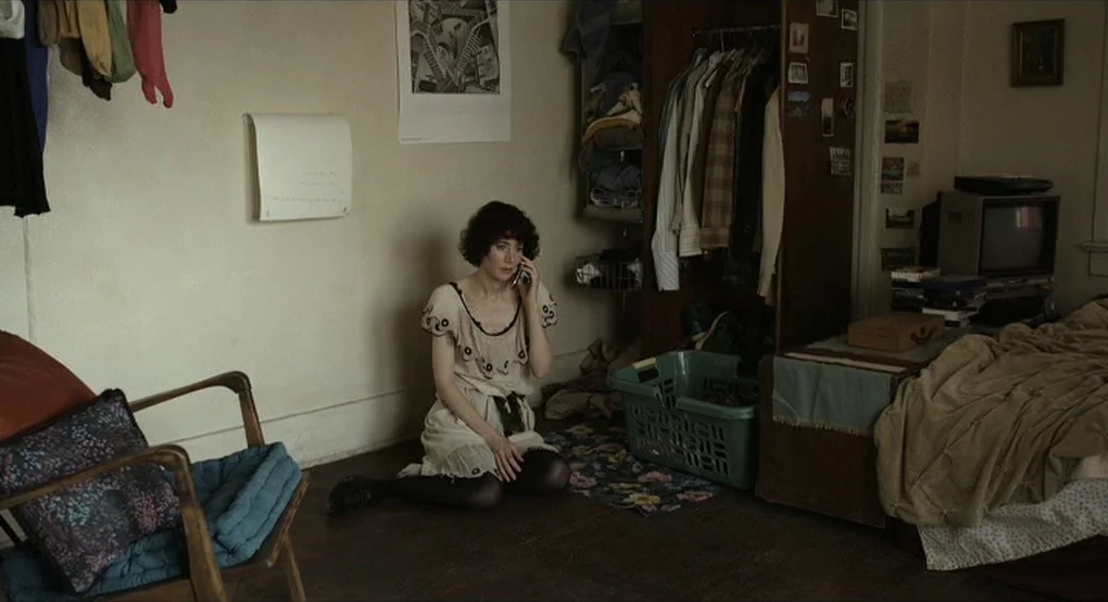 The Future (2011) movie still: medium — A cluttered apartment room features clothes hanging in an open wardrobe and a TV.