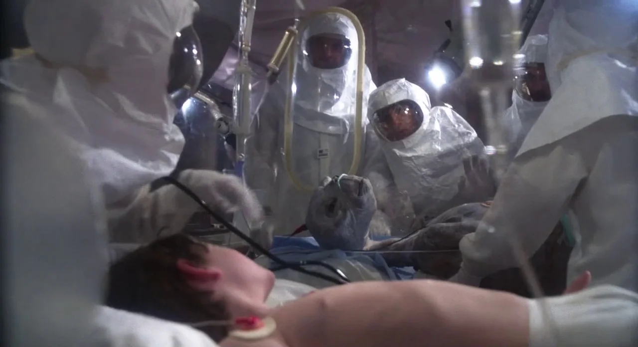 E.T. The Extra-Terrestrial (1982) movie still: medium — A makeshift medical tent contains several personnel in full-body white protective hazmat…