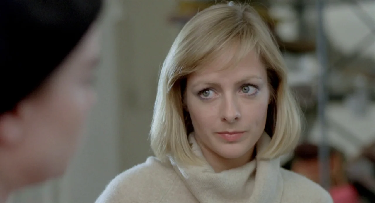 Ms. 45 (1981) movie still: closeup — A close-up shot of a blonde woman in a cream turtleneck sweater. She looks toward another person who is out of…