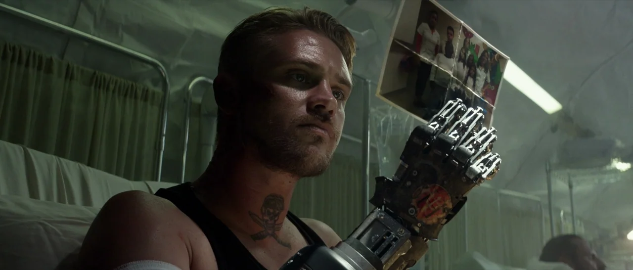 Logan (2017) movie still: medium — A dimly lit hospital ward with white privacy curtains visible in the background. A man with a robotic prosthetic…