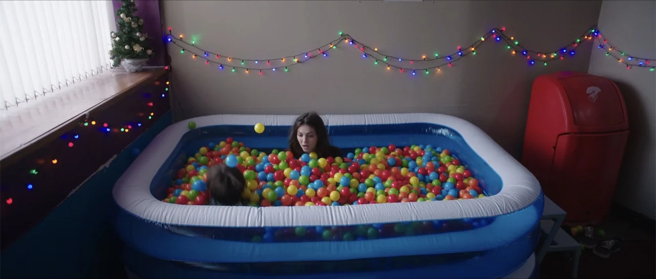 Anna and the Apocalypse (2018) movie still: medium — An indoor room features a blue inflatable pool filled with multicolored plastic spheres. A…
