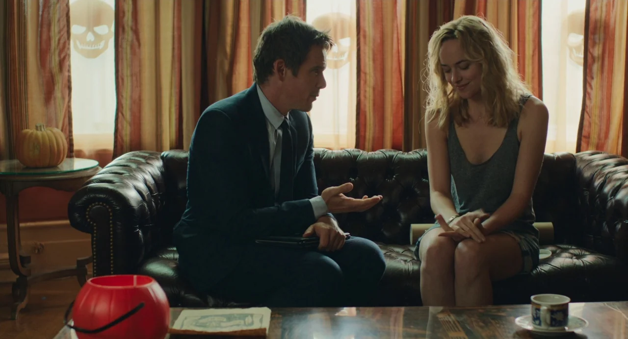 Cymbeline (2014) movie still: medium — A domestic interior features a tufted leather sofa positioned against a window with curtains. A man in a suit…