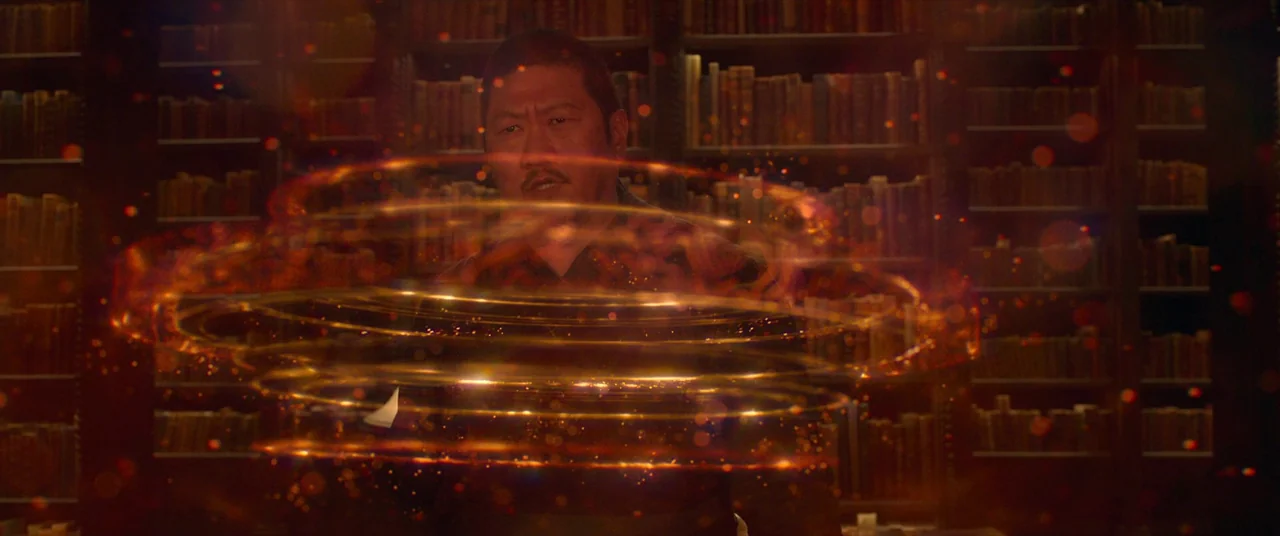 Shang-Chi and the Legend of the Ten Rings (2021) movie still: medium — A dark, wood-paneled room is filled with shelves of ancient, leather-bound…