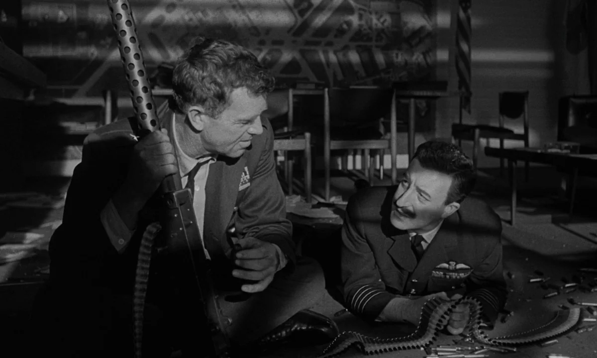 Dr. Strangelove or: How I Learned to Stop Worrying and Love the Bomb (1964) movie still: medium — A dark, sparsely furnished room features a wall…