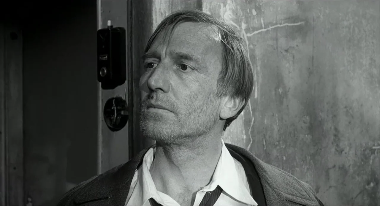 The Bohemian Life (1945) movie still: closeup — A man stands in a concrete stairwell against a rough-textured wall. The subject gazes toward the…