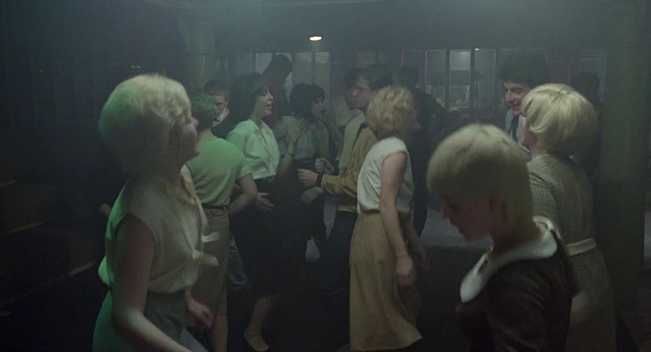 Quadrophenia (1979) movie still: medium — A crowded, smoke-filled room features men and women dancing in 1960s period clothing. Multiple individuals…