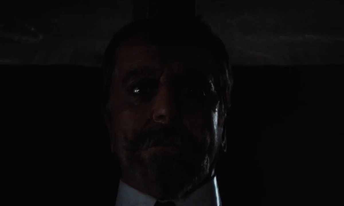 Tristana (1970) movie still: closeup — An older man with a mustache stands in a dimly lit, nondescript location. Only his face and shirt collar are…
