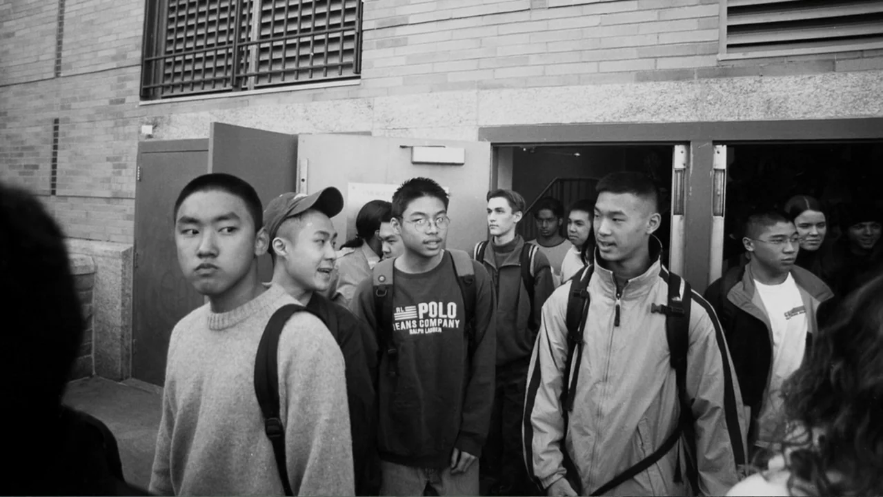 In the Shadow of the Towers: Stuyvesant High on 9/11 (2019) movie still: medium — A group of teenagers exits a brick school building through open…