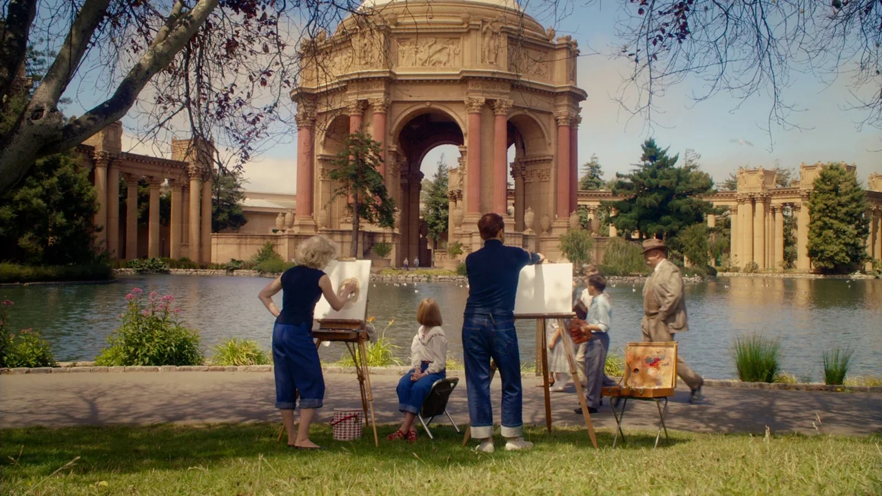 Big Eyes (2014) movie still: wide — A group of artists paints at easels in front of a classical rotunda structure. The scene is located by a pond in…