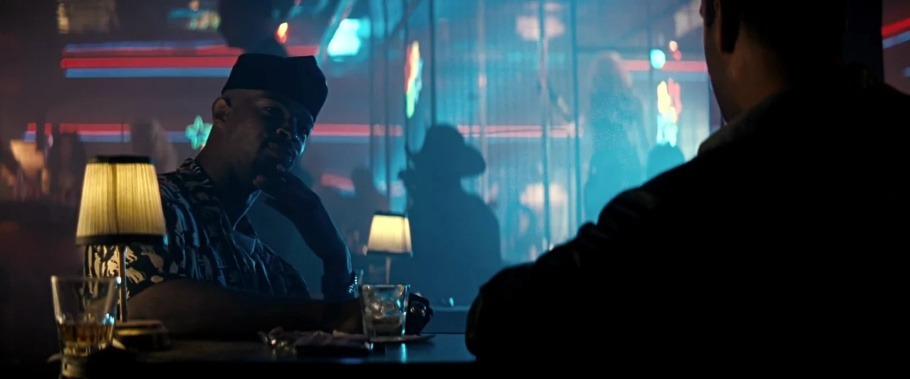 The Last Boy Scout (1991) movie still: medium — A dimly lit club interior features a table with small lamps and alcoholic drinks. A man wearing a…