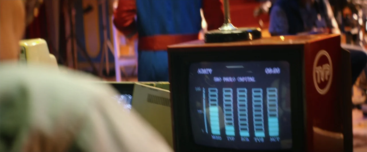 Bingo: The King of the Mornings (2017) movie still: medium — An interior space with a vintage television monitor displaying a glowing data graph. A…