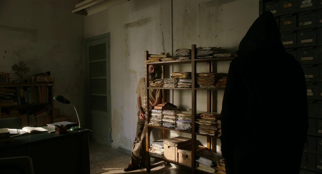 Crimes of the Future (2022) movie still: medium — A dusty archive room features metal storage lockers, wooden shelving units, and peeling wall…