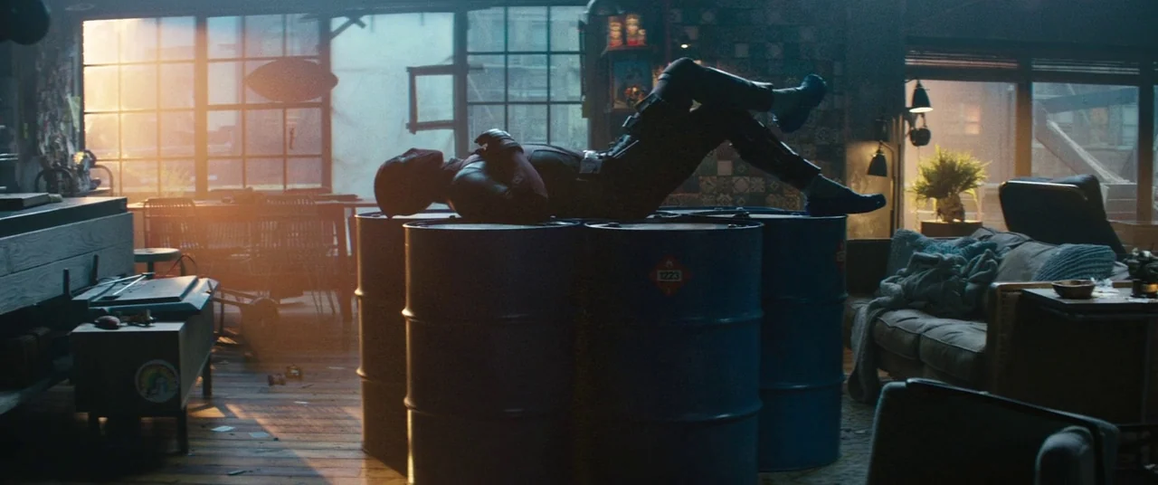 Deadpool 2 (2018) movie still: wide — An industrial-style loft with exposed wood floors and large windows facing city architecture. A costumed…