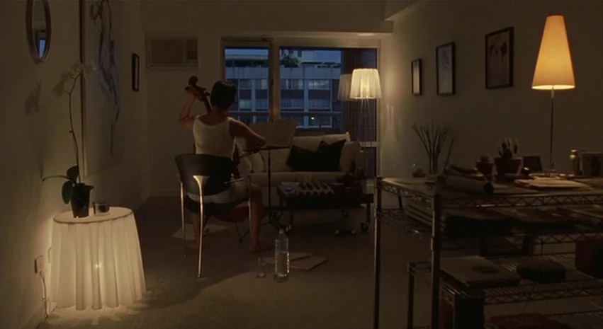 Yi-Yi (A One and A Two) (2000) movie still: wide — A dimly lit room at night contains a cello player facing a large window. A modern apartment…