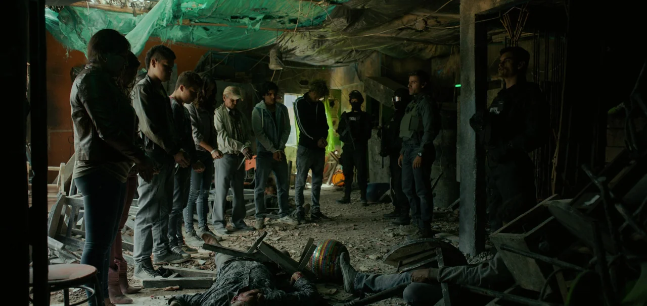 Triple Frontier (2019) movie still: wide — A dilapidated, trash-strewn room features a translucent plastic tarp covering the sagging ceiling…
