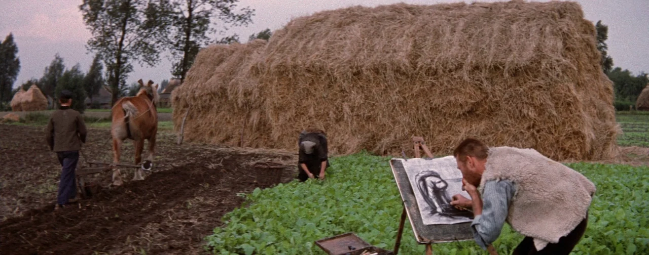 Lust For Life (1956) movie still: wide — A flat rural landscape features a large haystack and rows of green crops. One man sketches on an easel…