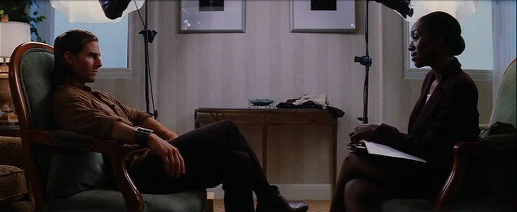 Magnolia (1999) movie still: medium — A quiet room features striped wallpaper, framed artwork, and two chairs facing one another. A man and a woman…