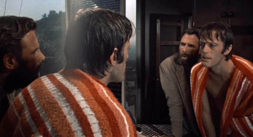 The Trip (1967) movie still: medium — A cramped bathroom contains a mirror reflecting the faces of two men. One man looks into the glass while…