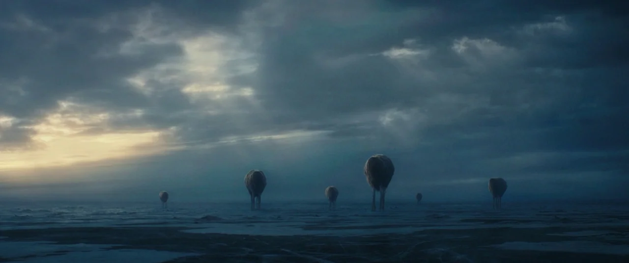A Wrinkle In Time (2018) movie still: wide — A vast, flat, frozen tundra extends toward a horizon obscured by dense, dark storm clouds. Multiple…