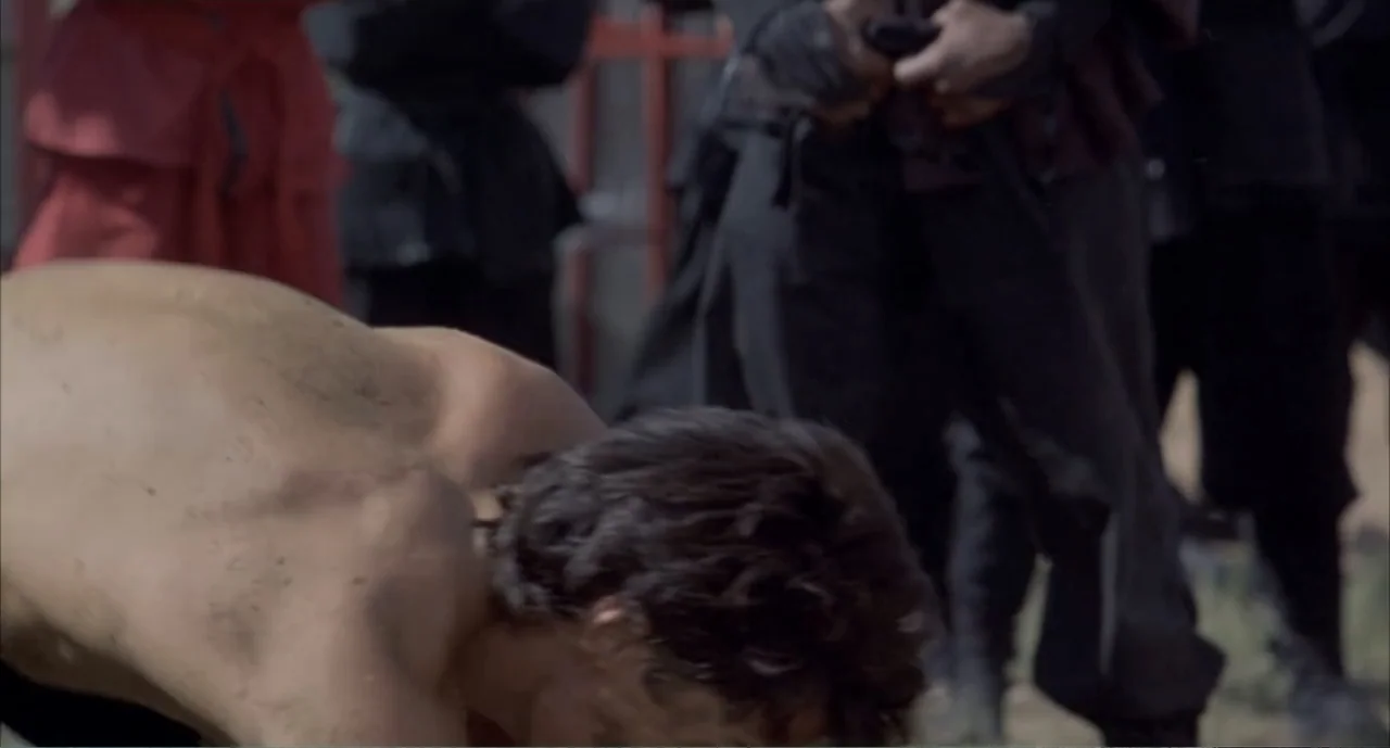 American Ninja 4: The Annihilation (1990) movie still: medium — An outdoor training area features a dirt floor and blurred figures in the…