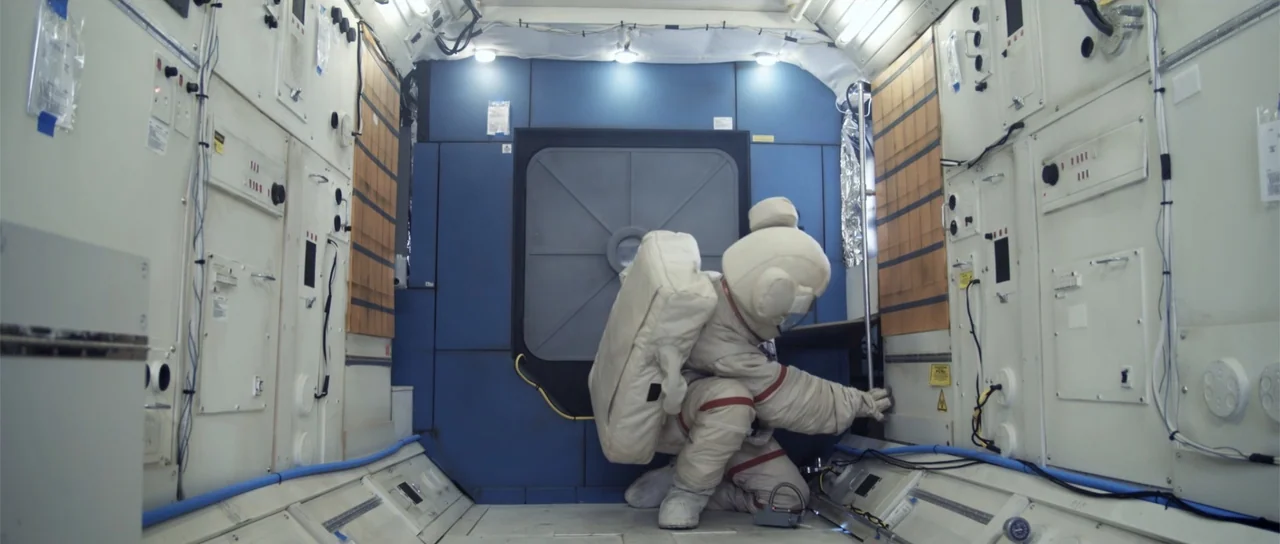 Astronaut: The Last Push (2012) movie still: medium — A high-tech module interior features blue and white wall panels with complex instrumentation.…
