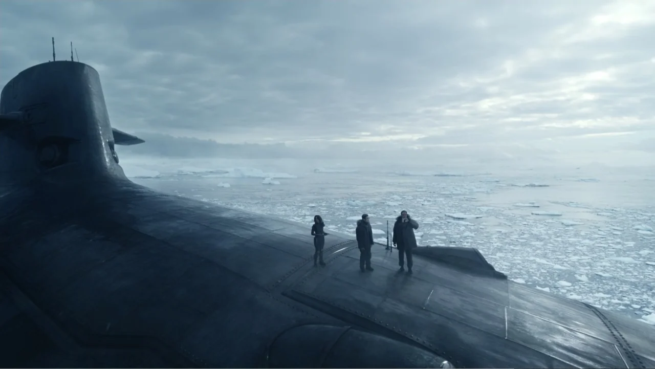 Aquaman and the Lost Kingdom (2023) movie still: wide — The deck of a large military submarine surfaces in an expansive field of floating ice. Three…