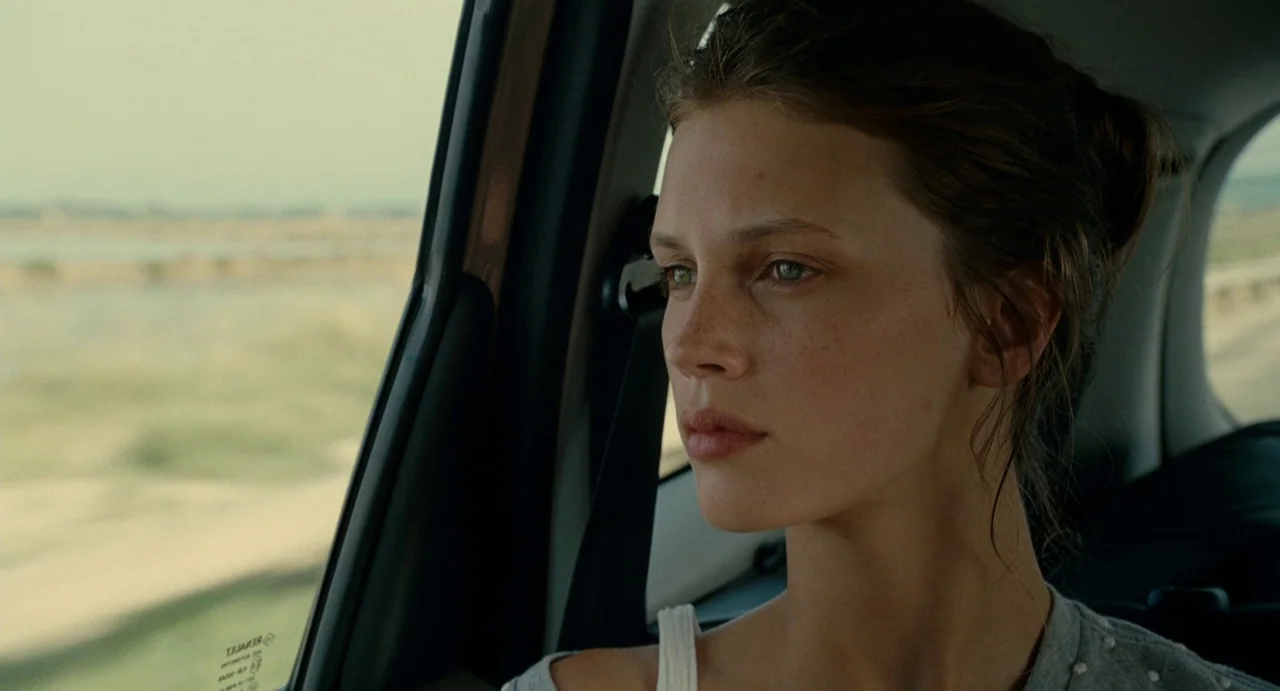 Young & Beautiful (2013) movie still: closeup — The interior of a passenger car shows a young woman sitting in the seat. She gazes out the window at…