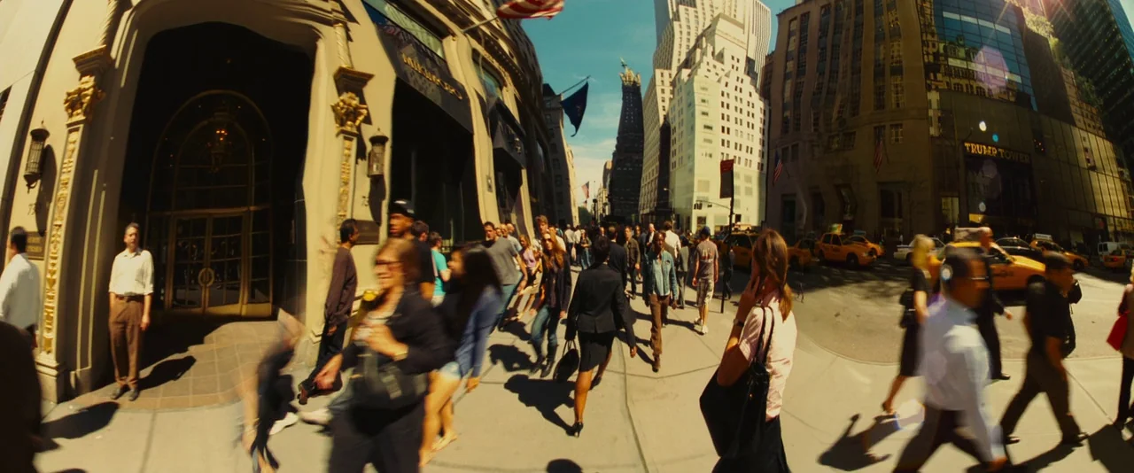 Limitless (2011) movie still: wide — A busy New York City sidewalk outside Trump Tower is populated by numerous walking pedestrians. The scene uses…