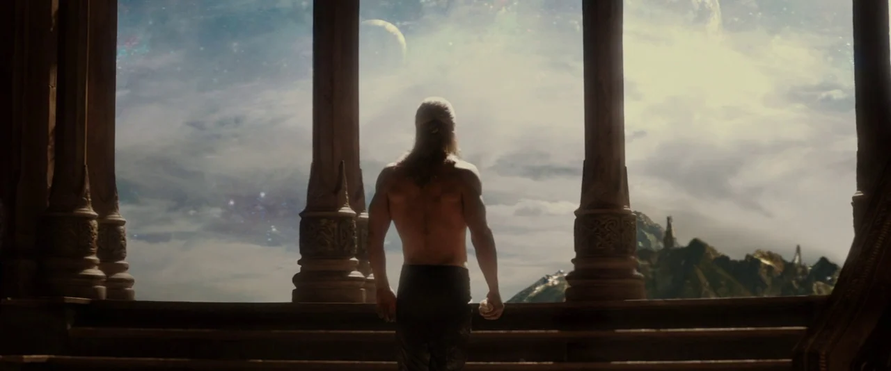 Thor: The Dark World (2013) movie still: fullbody — A stone balcony with carved pillars overlooks a distant mountainous landscape under a…
