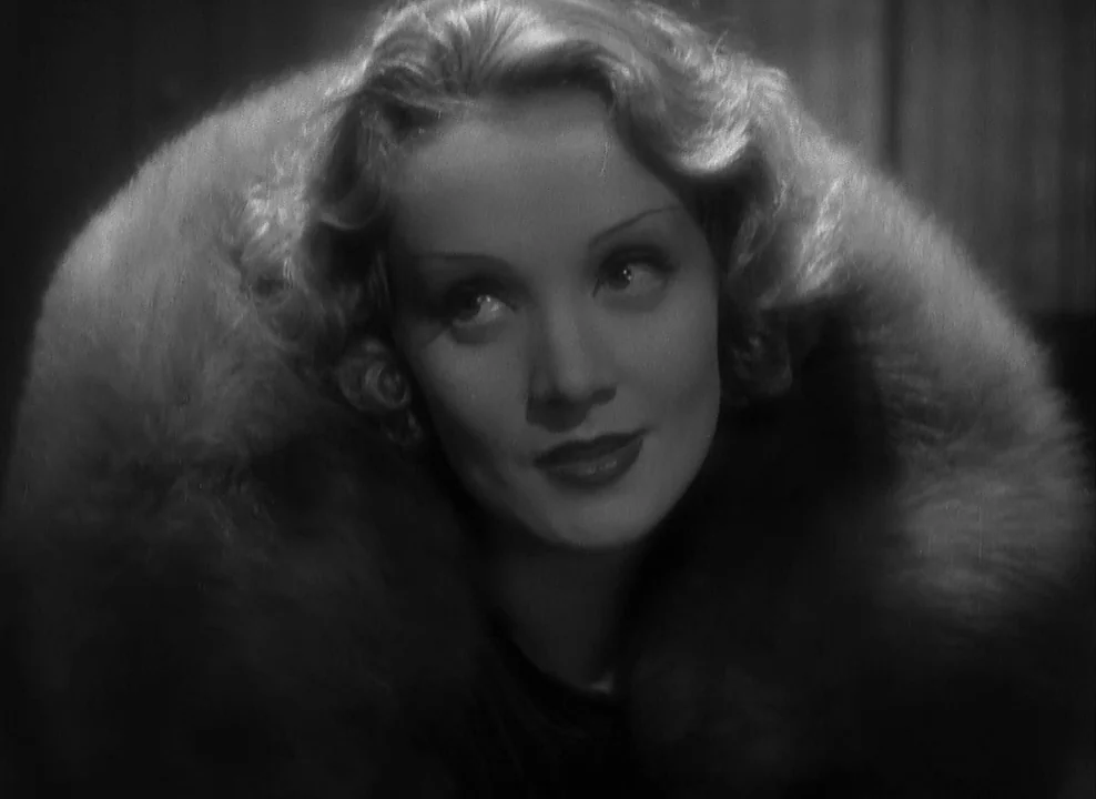 Shanghai Express (1932) movie still: closeup — A close portrait of a woman wearing a heavy fur collar against a dark background. She turns her head…