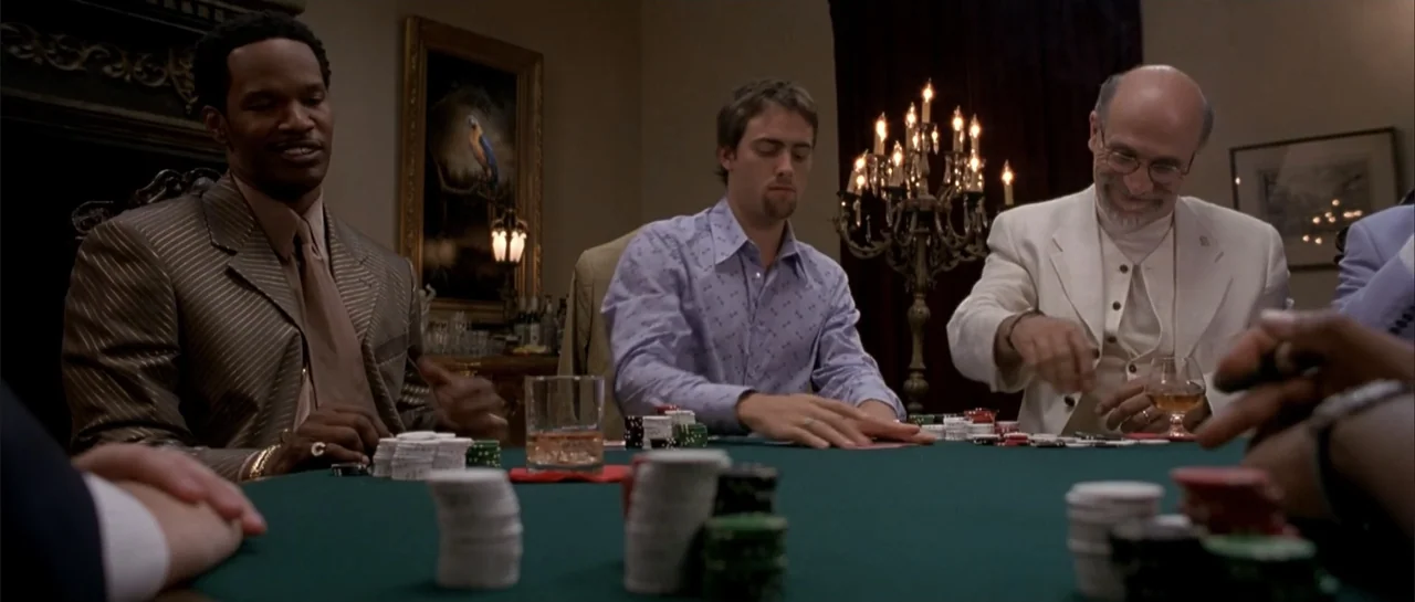 Shade (2003) movie still: medium — A dimly lit room contains a green poker table with chips and cards. Three men participate in a card game while…