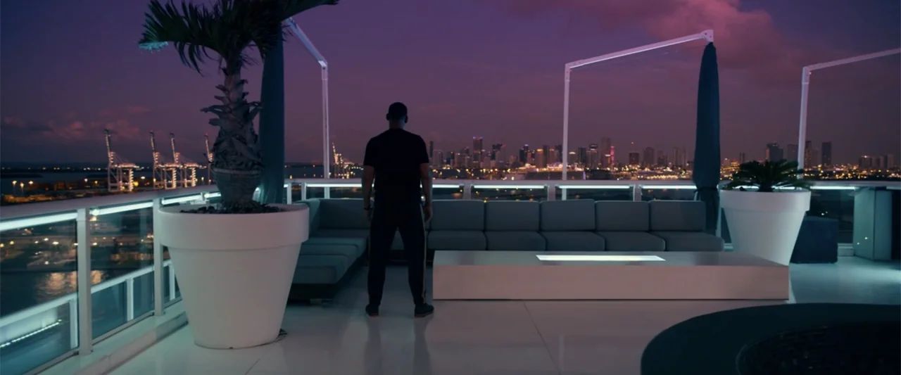 Bad Boys for Life (2020) movie still: fullbody — A luxury modern rooftop terrace at dusk with a view of a coastal city. A man stands at the railing…