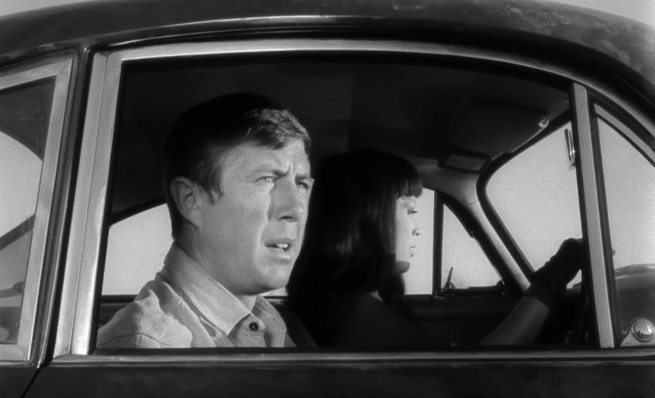 Faster, Pussycat! Kill! Kill! (1965) movie still: medium — The interior of a moving car shows a man and woman in profile view. The woman holds the…