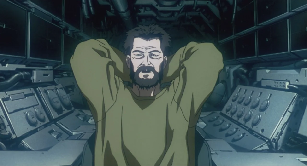 Ghost in the Shell (1995) movie still: medium — A cramped technological space is filled with panels, buttons, and switches. A bearded man sits in a…