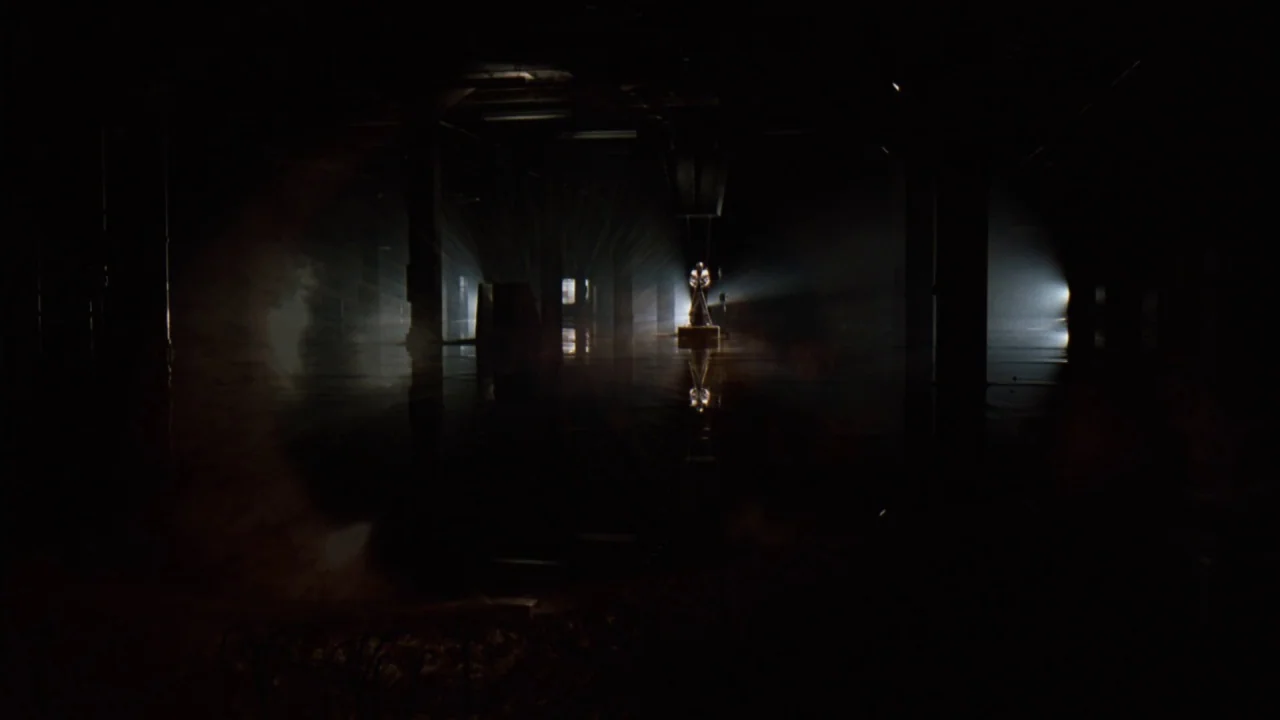 Jason X (2001) movie still: wide — A vast, dark, flooded industrial space with rhythmic concrete pillars and low ceilings. A single, distant light…