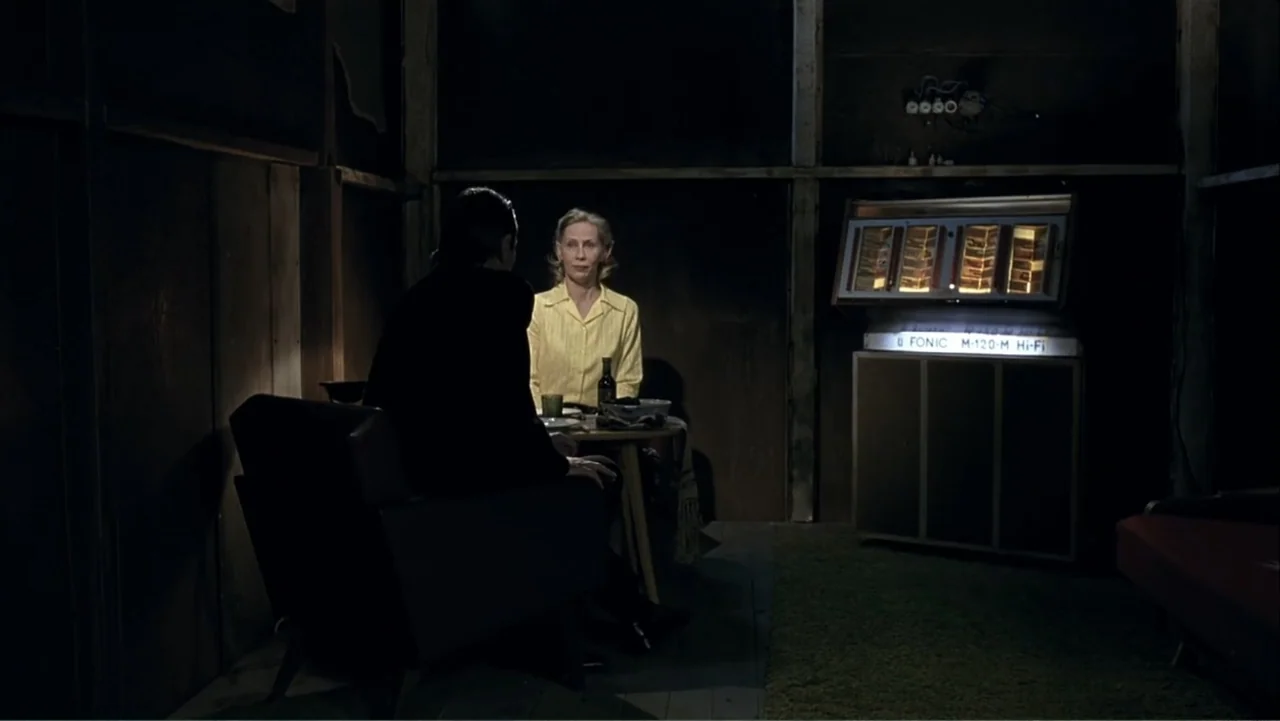 The Man Without a Past (2002) movie still: medium — A dark, wood-paneled room features a vintage wall-mounted hi-fi audio system glowing brightly. A…