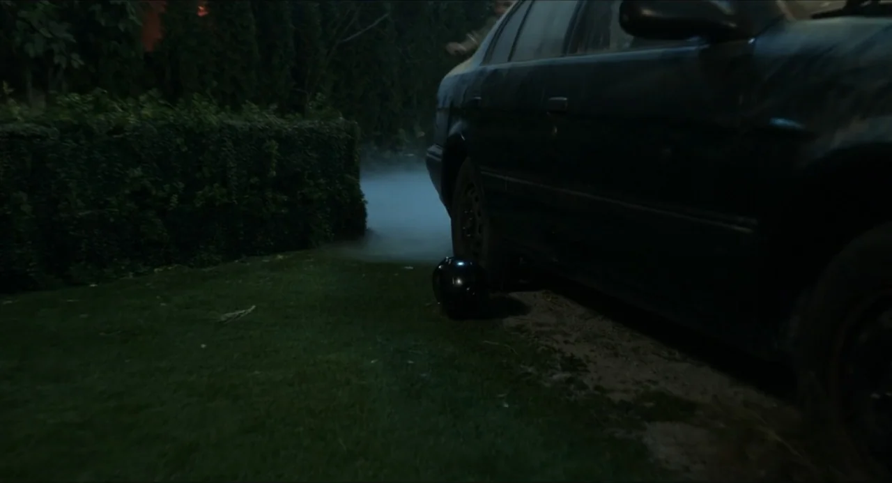 Henry Danger: The Movie (2025) movie still: medium — A dark residential lawn with a thick hedge bordering the edge of the frame. A black motorcycle…